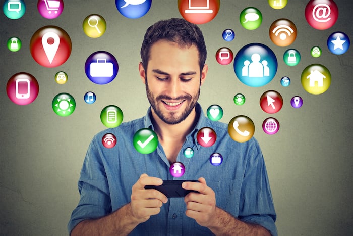 Man looking at a phone with icons around him