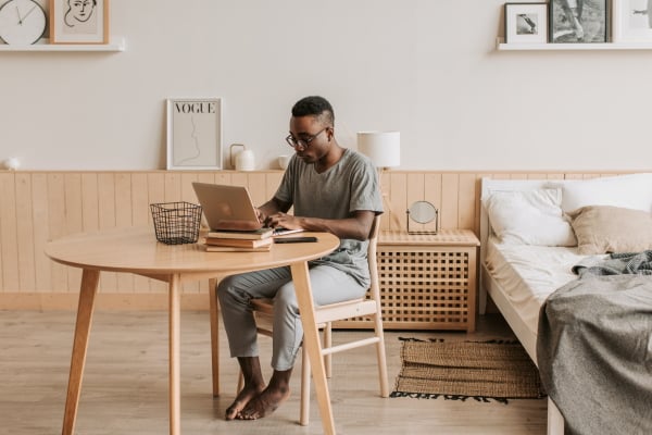 Man sitting at wooden table with laptop